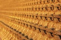 Blurred background image of wall in ancient asian buddhist temple with umpteen small golden Buddha statues. Royalty Free Stock Photo