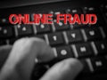 Blurred background keyboard and finger with text ONLINE FRAUD.