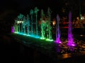 Blurred background of light fountain with round light bokeh at night.Beautiful multicolored dancing fountains at night.fountain