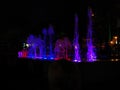 Blurred background of light fountain with round light bokeh at night.Beautiful multicolored dancing fountains at night.fountain