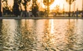 Blurred background with long shadows from trees in park. Silhouettes of unrecognizable people walking in park Royalty Free Stock Photo