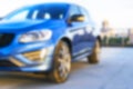 Blurred background of a A modern luxury car on the blur roof of the building. Modern car exterior details.