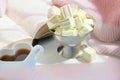 Blurred background of morning still life, coffee in bed. White cup in shape heart and fluffy scarf. Shadow and sunlight. At home. Royalty Free Stock Photo