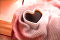 Blurred background of morning still life, coffee in bed. White cup in shape heart and fluffy scarf. Shadow and sunlight. At home. Royalty Free Stock Photo