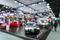 Blurred background of new cars displayed in luxury showroom with light bokeh, motor show event Royalty Free Stock Photo