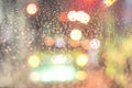 Blurred background. Night city lights blur. Road view through car window with rain drops Royalty Free Stock Photo