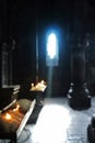 Blurred background of old Armenian christian church monastery interior with a sun ray falling to the candles from a window Royalty Free Stock Photo