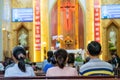 A blurred background photo of the inside of a Vietnamese church sanctuary that is filled with people in the pews, and the pastor