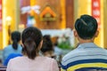 A blurred background photo of the inside of a Vietnamese church sanctuary that is filled with people in the pews, and the pastor