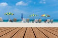 Blurred beach chairs and umbrellas blue sea & sky background with empty wooden Royalty Free Stock Photo