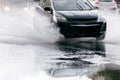 Blurred black car on wet road during downpour