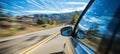 Blurred bokeh effect car gracefully driving up winding mountain road with dreamy blurred clouds