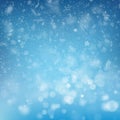 Blurred bokeh light snowflakes on blue background. Christmas and New Year holidays template. Abstract glitter defocused Royalty Free Stock Photo