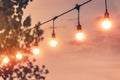 Blurred light on sunset with yellow string lights decor in beach restaurant Royalty Free Stock Photo