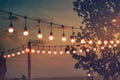 Blurred light on sunset with yellow string lights decor in beach restaurant Royalty Free Stock Photo