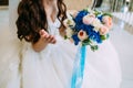 Blurred Bride holds bouquet with creamy roses and peonies and blue hydrangeas. Wedding morning. Close-up Royalty Free Stock Photo