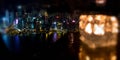 Blurred burning candle in glass cup with Hong Kong island night view