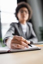 Blurred businesswoman writing on copy book