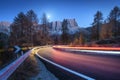 Blurred car headlights on winding road in mountains at night