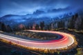 Blurred car headlights on winding road in mountains at night Royalty Free Stock Photo