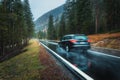 Blurred car in motion on the road in autumn forest in rain Royalty Free Stock Photo