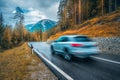 Blurred car in motion on the road in orange forest in autumn Royalty Free Stock Photo