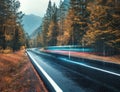 Blurred car on the road in autumn forest in rain Royalty Free Stock Photo