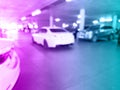 Blurred cars in car parking lot in shopping mall. Bokeh lights background. Abstract blue and pink blur car parking lot for Royalty Free Stock Photo