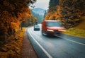 Blurred cars on the road in autumn foggy forest in rainy day Royalty Free Stock Photo