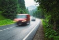 Blurred cars on the road in foggy forest in rainy day Royalty Free Stock Photo