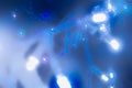 Blurred Christmas background with blue lights on the Christmas tree in a white haze Royalty Free Stock Photo