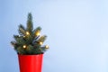 Blurred Christmas background. Christmas tree in a red bucket with garland with lights on blue background Royalty Free Stock Photo