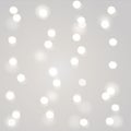 Blurred Christmas garland white lights on gray background. New Year decoration. Royalty Free Stock Photo