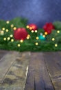 Blurred Christmas, New Year background with defocused fir tree branches, toys, blurry lights. Wooden board with small clear space Royalty Free Stock Photo