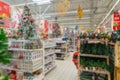 Sale of festive Christmas accessories and trees in a retail store. Blurred background in the store Royalty Free Stock Photo