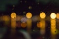 Blurred city lights with rain drops foreground. Unfocused colorful lights behind glass with drops. Shiny lights of night bokeh. Royalty Free Stock Photo