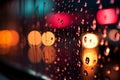 Blurred city lights seen through a window with colorful raindrops Royalty Free Stock Photo