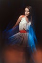 Blurred color art portrait of a girl on a dark background. Fashion woman with beautiful makeup and a light summer dress. Sensual