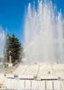 Blurred colorful rainbow on a background of splashing fountain on a Sunny summer day, vertical shot