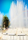 Blurred colorful rainbow on a background of splashing fountain on a Sunny summer day, vertical shot Royalty Free Stock Photo
