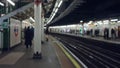 Blurred commuters stand on a london underground platform with defocused lighting creating a bokeh effect in a busy metro Royalty Free Stock Photo