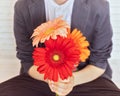 Schoolboy with a bouquet of colorful gerberas in his hands on a light background