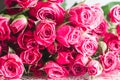 Blurred creative background of pink rose flowers. Partially defocused roses, on glossy surface with water drops