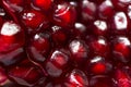 Blurred creative food pattern background from radiant pomegranate seeds of vibrant dark red color. Healthy diet vitamins