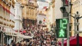 Blurred crowd people on street of city near traffic light with sign of pedestrian. Concept modern city life