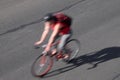 Blurred cyclist with red shirt and backpack on torn grunge asphalt city street Royalty Free Stock Photo