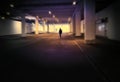 Blurred dark person walks in the center of a black corridor to an illuminated passage, abstract, intentional zoom blur