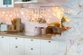 Blurred defocused view on interior of modern white kitchen with pink walls and blue decor on a Christmas New year eve. Pine tree Royalty Free Stock Photo