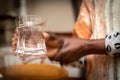 Blurred effect on the hands of a Parkinson`s disease patient with tremors while holding a glass