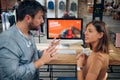 Blurred faces of young man and woman colleagues talking in front of table with desktop computer, in clothing store Royalty Free Stock Photo